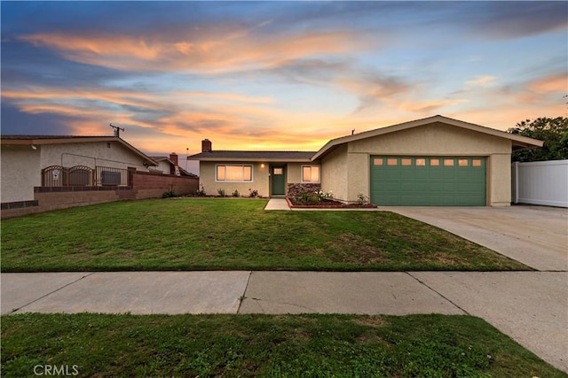 view of front of home featuring fence, an attached garage, stucco siding, a front yard, and driveway