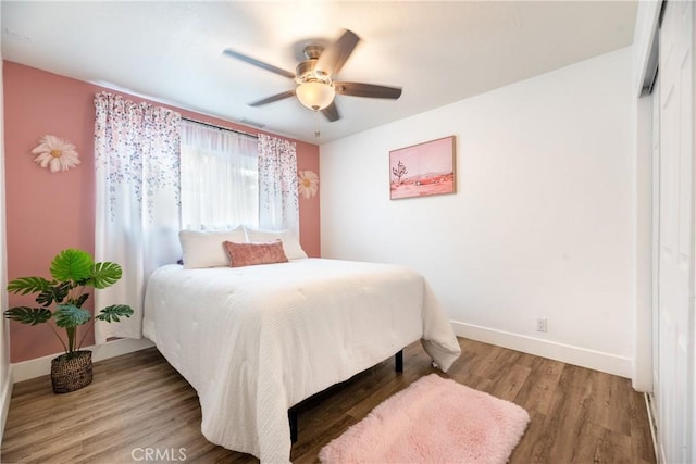 bedroom with baseboards, ceiling fan, and wood finished floors