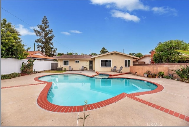 view of swimming pool with a fenced backyard, a patio area, and a pool with connected hot tub