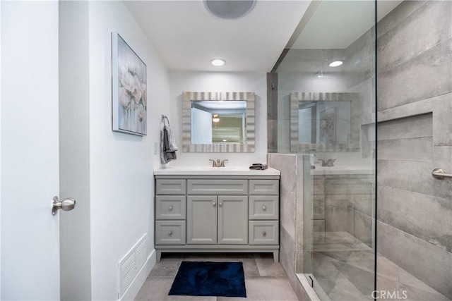 full bathroom with vanity, visible vents, baseboards, tiled shower, and recessed lighting