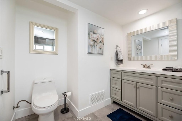 half bathroom featuring visible vents, baseboards, toilet, and vanity