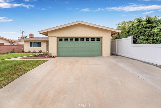 view of front of property featuring concrete driveway, a garage, fence, and stucco siding