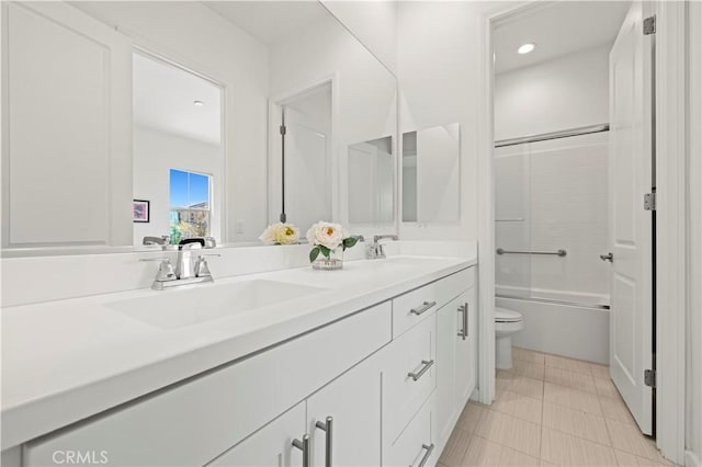 bathroom featuring a sink, washtub / shower combination, toilet, and double vanity