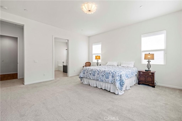 carpeted bedroom featuring baseboards and ensuite bathroom