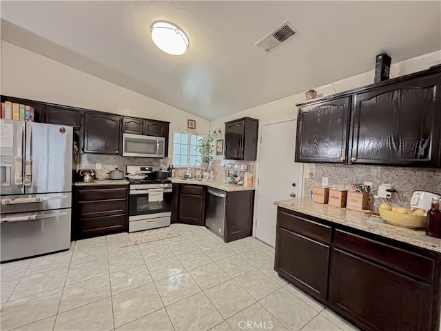 2901 Flint Hills Dr, Bakersfield, CA 93313 - kitchen featuring appliances with stainless steel finishes, visible vents, light tile patterned floors, backsplash, and vaulted ceiling
