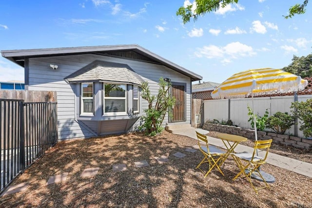 back of property with a fenced backyard and entry steps