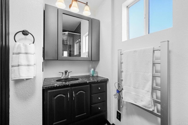 full bathroom with vanity and a textured wall