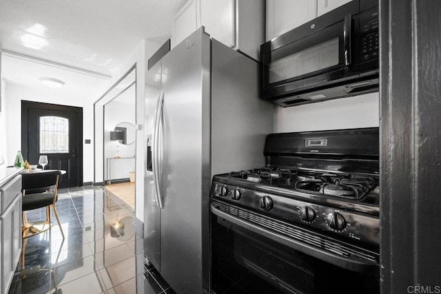 kitchen featuring tile patterned floors, white cabinets, and black appliances