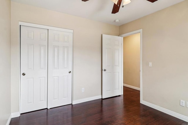 unfurnished bedroom with baseboards, ceiling fan, a closet, and dark wood-style flooring