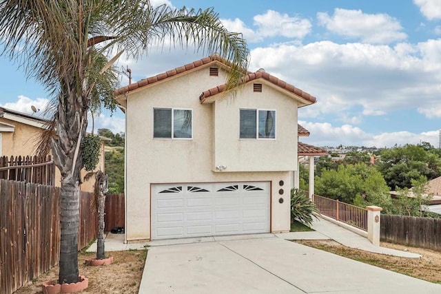 mediterranean / spanish home with a garage, fence, stucco siding, driveway, and a tile roof