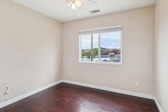 empty room with visible vents, a ceiling fan, baseboards, and dark wood-type flooring
