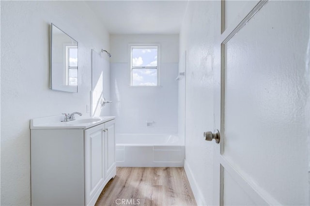 1144 W 57th St, Los Angeles, CA 90037 - full bath featuring wood finished floors, shower / bathtub combination, and vanity