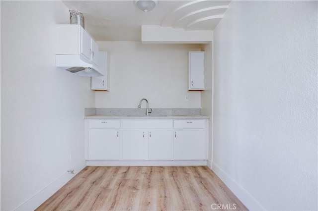 1144 W 57th St, Los Angeles, CA 90037 - kitchen featuring baseboards, a sink, light wood-style flooring, and light countertops