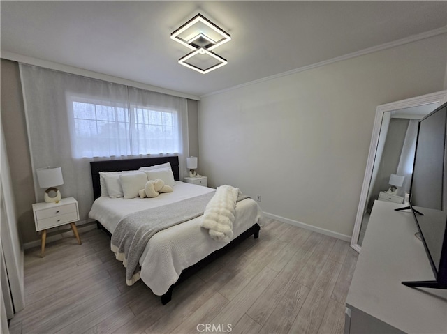 bedroom with baseboards, ornamental molding, and light wood-type flooring