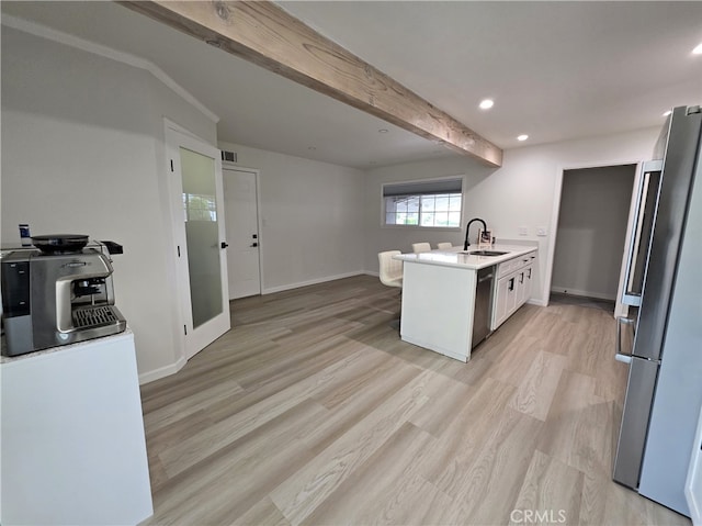 kitchen featuring a peninsula, light wood finished floors, a sink, stainless steel appliances, and recessed lighting