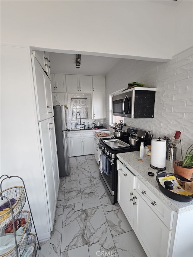 1030 E Ocean Blvd Unit 210, Long Beach, CA 90802 - kitchen with stainless steel appliances, light marble finish flooring, white cabinetry, and light stone counters
