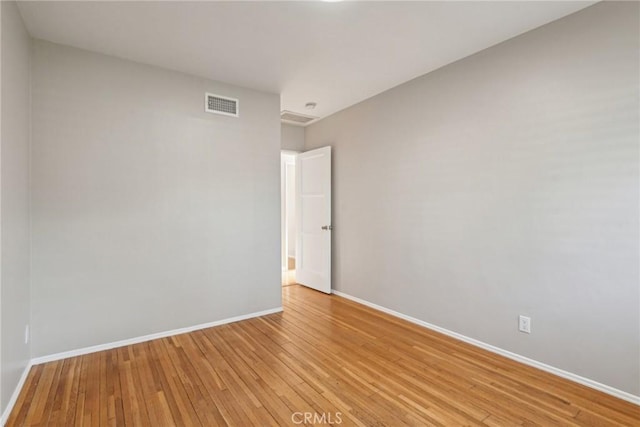 unfurnished room featuring light wood-style floors, baseboards, and visible vents