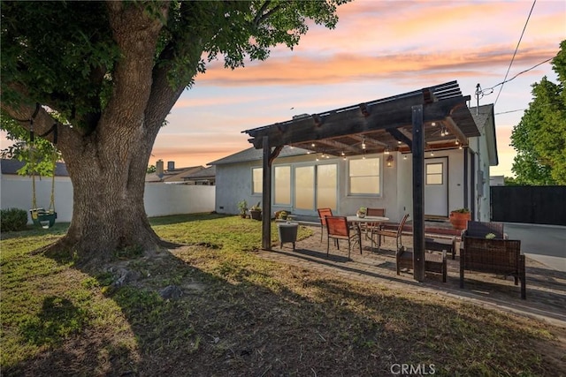 back of house with a pergola, stucco siding, a fenced backyard, a patio area, and a lawn