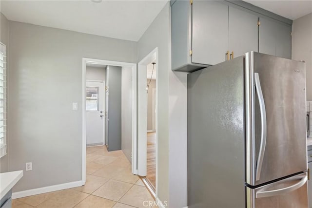 17048 Baltar St, Lake Balboa, CA 91406 - kitchen with light tile patterned flooring, light countertops, freestanding refrigerator, baseboards, and gray cabinetry