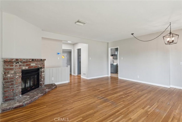 17048 Baltar St, Lake Balboa, CA 91406 - unfurnished living room with an inviting chandelier, a fireplace, light wood-style flooring, baseboards, and visible vents