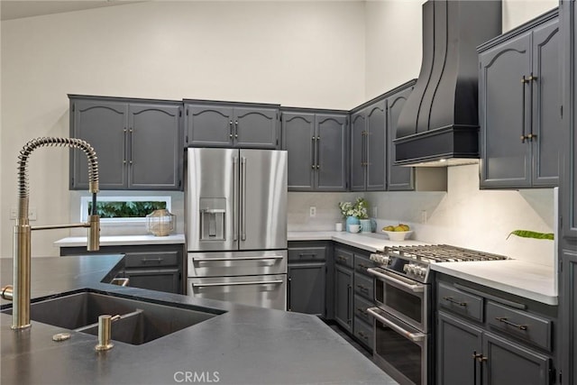 kitchen featuring custom range hood, a sink, tasteful backsplash, and stainless steel appliances
