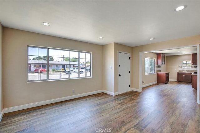 unfurnished living room with baseboards, recessed lighting, and wood finished floors
