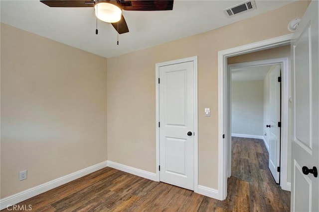unfurnished bedroom featuring visible vents, a ceiling fan, baseboards, and wood finished floors