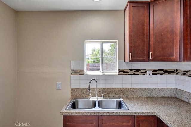 kitchen featuring light countertops, a sink, and tasteful backsplash