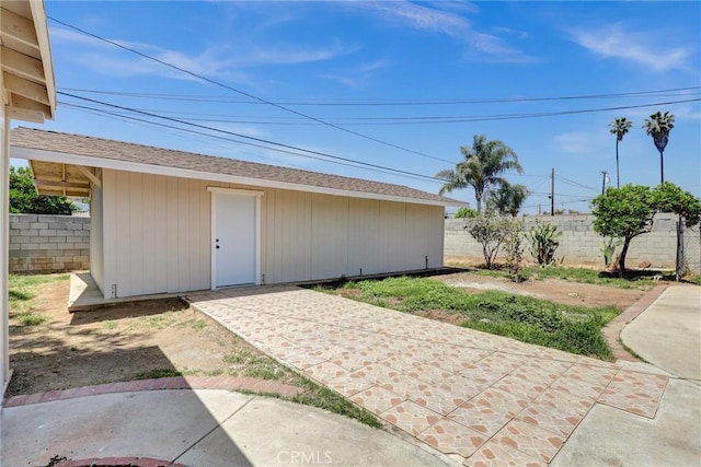 view of outdoor structure with fence and an outbuilding