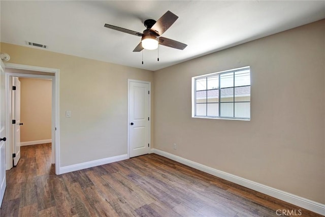 unfurnished bedroom featuring baseboards, ceiling fan, wood finished floors, and visible vents