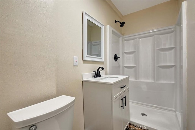 full bath featuring vanity, a shower, and toilet