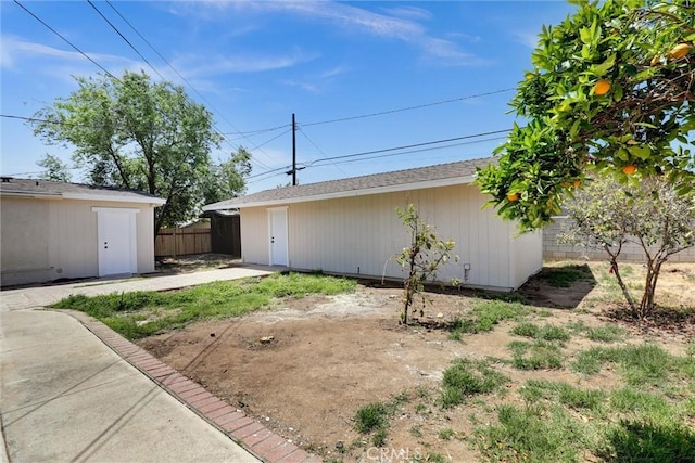 view of yard featuring a patio area, fence, and an outbuilding