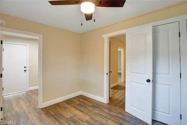 unfurnished bedroom featuring baseboards, ceiling fan, and wood finished floors