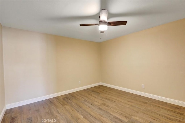 empty room with baseboards, a ceiling fan, and wood finished floors