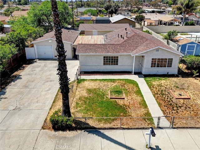 view of front facade featuring a residential view, stucco siding, concrete driveway, and fence private yard