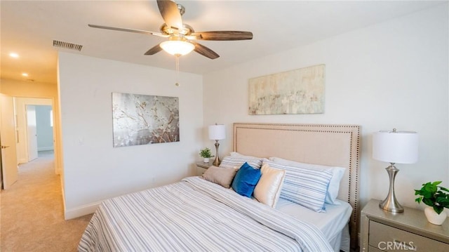 bedroom featuring visible vents, a ceiling fan, and light carpet