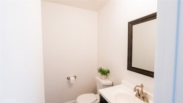 bathroom with vanity, baseboards, and toilet