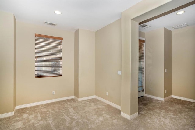 carpeted empty room with visible vents, recessed lighting, and baseboards