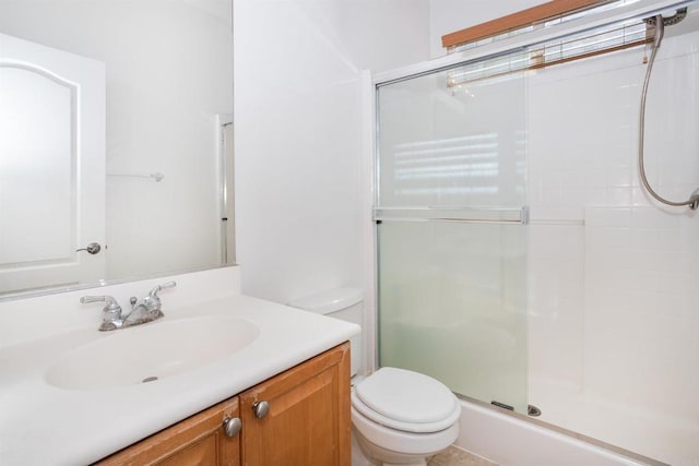 bathroom featuring vanity, a shower stall, and toilet