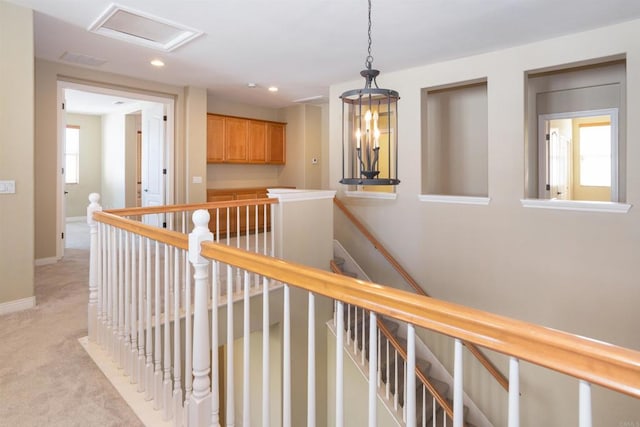 corridor featuring light colored carpet, attic access, recessed lighting, baseboards, and an upstairs landing