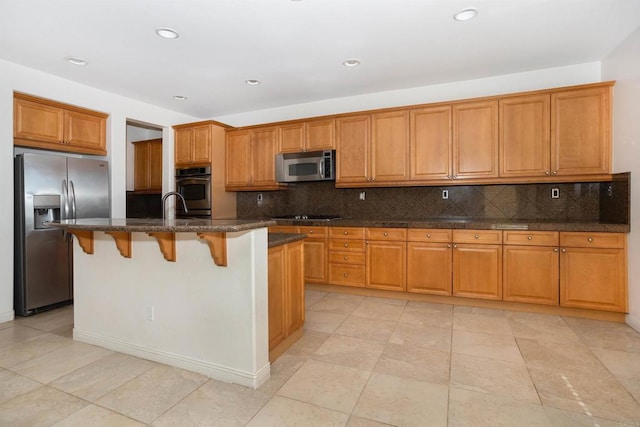 kitchen featuring stainless steel appliances, brown cabinetry, and tasteful backsplash