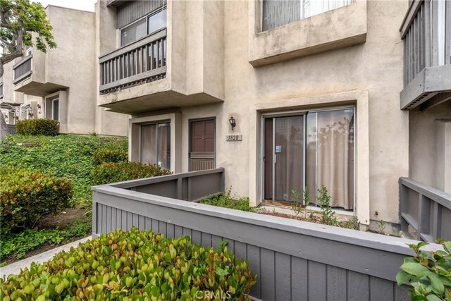 view of exterior entry featuring a balcony