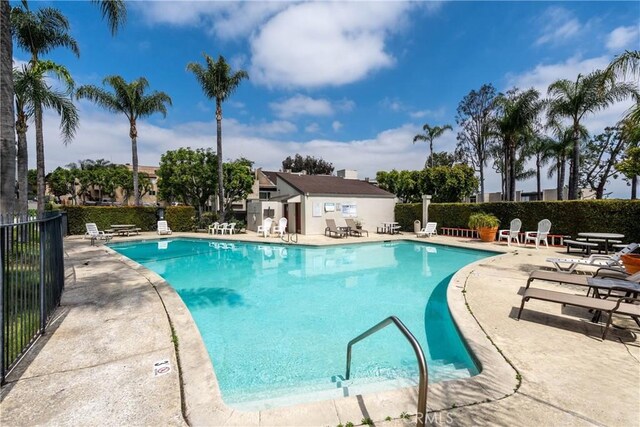 community pool featuring fence and a patio area