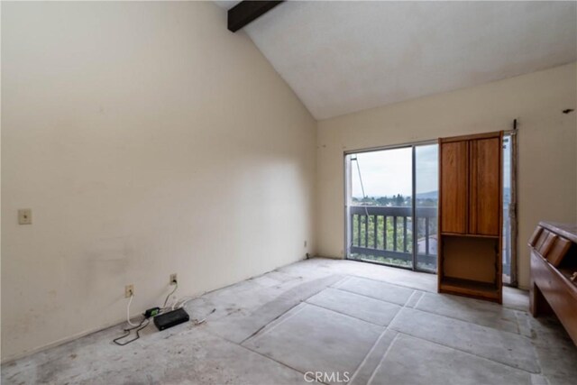 spare room featuring beam ceiling and high vaulted ceiling