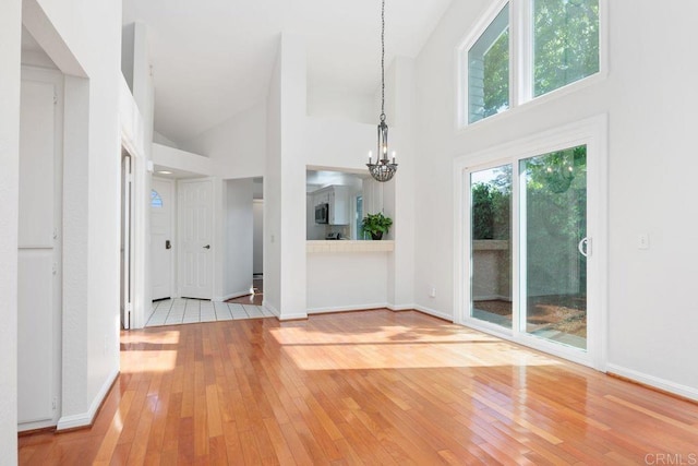 814 Okra Ct, Carlsbad, CA 92011 - unfurnished dining area with high vaulted ceiling, light wood-style flooring, and a chandelier