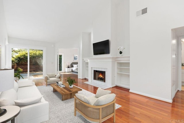 814 Okra Ct, Carlsbad, CA 92011 - living area featuring a fireplace, high vaulted ceiling, and light wood-style flooring