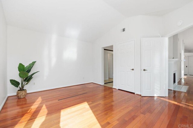814 Okra Ct, Carlsbad, CA 92011 - unfurnished living room with hardwood / wood-style flooring, lofted ceiling, and a fireplace with flush hearth