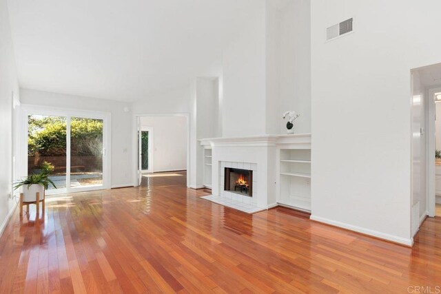 814 Okra Ct, Carlsbad, CA 92011 - unfurnished living room with a tile fireplace, wood finished floors, and a towering ceiling