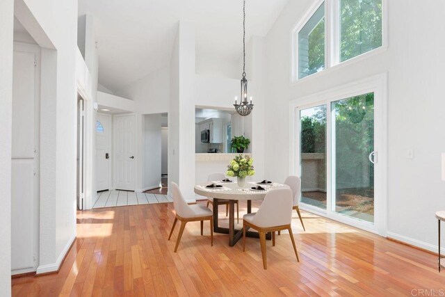 814 Okra Ct, Carlsbad, CA 92011 - dining space featuring high vaulted ceiling, light wood-style flooring, and a chandelier