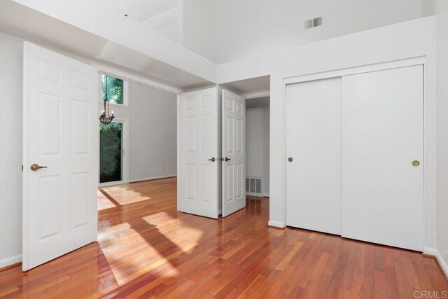814 Okra Ct, Carlsbad, CA 92011 - unfurnished bedroom with light wood-type flooring, a chandelier, and a closet
